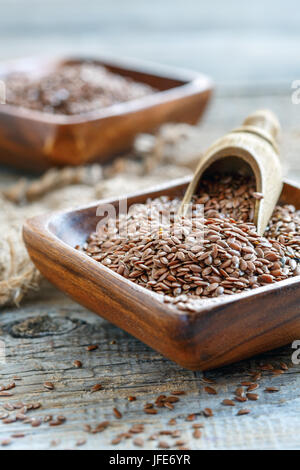 Wooden scoop in a bowl with brown flax. Stock Photo