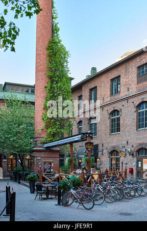 Courtyard outdoor café and dining on a late summer evening in Tampere, set in refurbished old red brick factory buildings Stock Photo