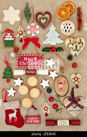 Symbols of christmas with bauble decorations, ornaments and signs on handmade hemp paper background. Stock Photo