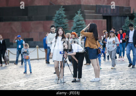 Moscow, RUSSIA - June 23, 2017: Asian tourists put a tripod on Red Square and shoot a video. Stock Photo