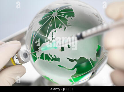 A globe with syringe and medicine to illustrate a cure for a worldwide pandemic.