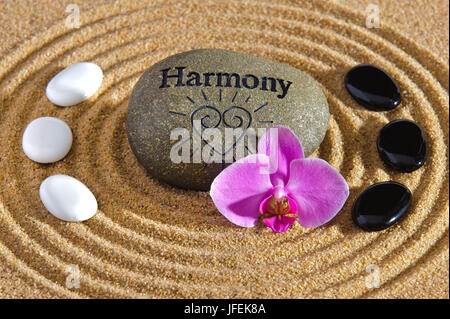 Japanese ZEN garden with stone of the harmony in the centre, yin and yang stones in the circle, orchid blossom, Stock Photo