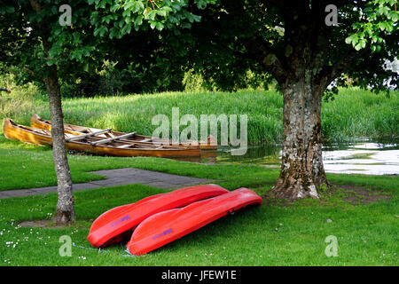Wooden Rowing Boats and red Canoes at Lusty Beg Boa Island Lough ErneCounty Fermanagh Northern Ireland Stock Photo