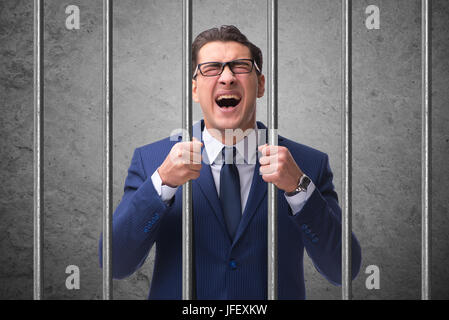 Young businessman behind the bars in prison Stock Photo