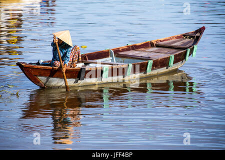 Woman in a rowboat lookoing for tourist customers on the Thu Bon River in Hoi An, Vietnam Stock Photo