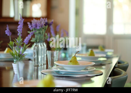 Selective focus photo of a plate with a pear on a dining table Stock Photo