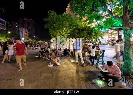 People sitting on the ground in Nguyen Hue Street, Ho Chi Minh City, Vietnam, Asia Stock Photo