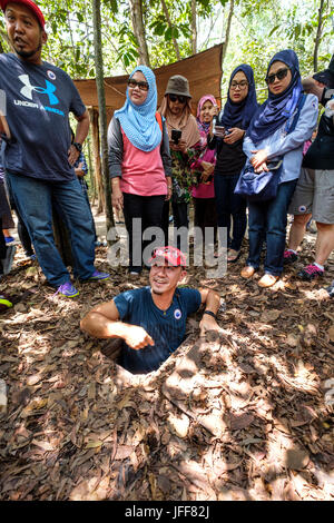 Tourist at the entrance to the Ben Duoc tunnel system used by vietcong combatants during the Vietnam war in Cu Chi, near Ho Chi Minh City, Vietnam Stock Photo