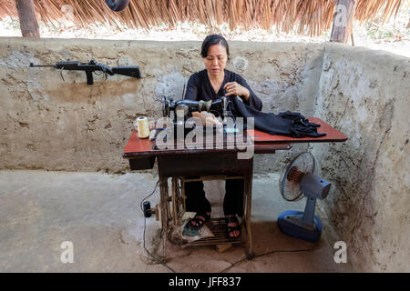 Re-enactment of a vietcong woman mending a guerrilla soldier uniform with a sewing machine in Cu Chi, Vietnam, Asia Stock Photo