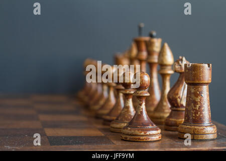 Ancient wooden chess pieces on an old chessboard. Stock Photo