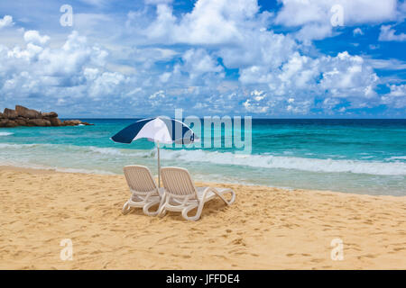 Chairs and umbrella at tropical beach Stock Photo