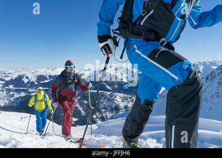 Skiers walking on snow mountain against sky Stock Photo