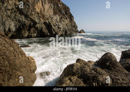 Water rushes between rocks in a cove on the Big Sur coast. Stock Photo