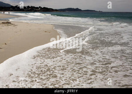 Waves and surf surging onto sandy Carmel Beach. Stock Photo