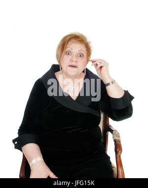 Senior woman putting hearing aid on. Stock Photo