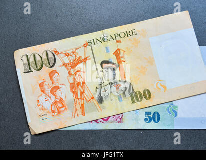 Singapore banknotes (50-100 SGD) on the granite floor - currency concept - close up. Stock Photo