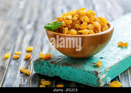 Dried grapes in a wooden bowl. Stock Photo