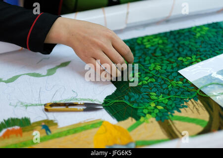 Vietnamese artisan creating a colorful tapestry at Công ty TNHH Mỹ Nghệ Hồng Ngọc workshop in Dong Trieu, Vietnam, Asia Stock Photo