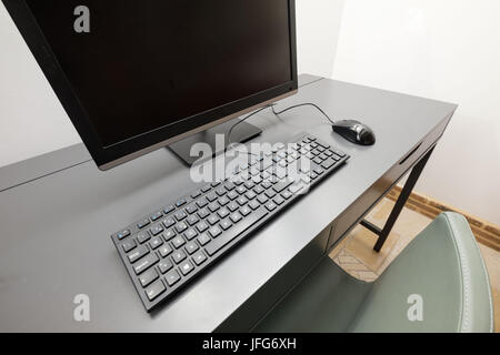 Desktop computer with monitor, keyboard and wired mouse on a desk Stock Photo