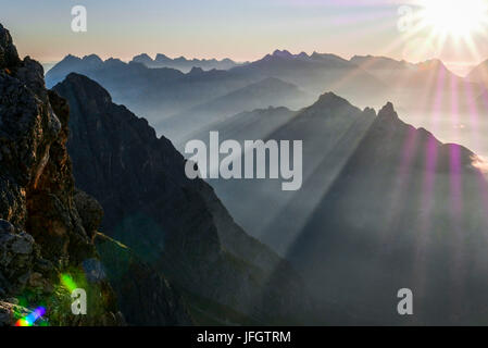 Sunrise and sunrays over the Karwendel with Wörner and eastern Karwendel point and Birkkarspitze and Überschalljoch Arnspitzen in the middle ground, on the left Öfelekopf in Wetterstein Range, view of Schüsselkarspitze, Stock Photo