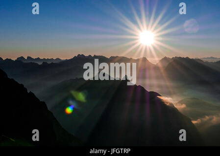 Sunrise and sunrays over the Karwendel with eastern Karwendel point and Birkkarspitze and Übersachallljoch and Bettelwurf, on the right Glockner and Venediger, Arnspitzen in the middle ground, view of Schüsselkarspitze in Wetterstein Range, Stock Photo