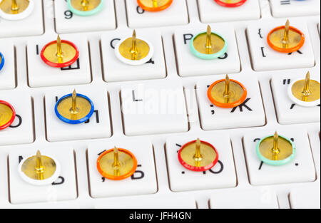 Pins on computer keyboard Stock Photo