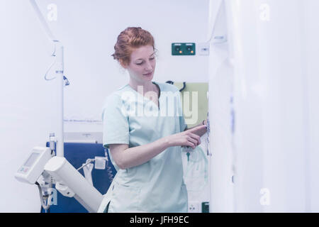 Female nurse operating X-ray machine Stock Photo
