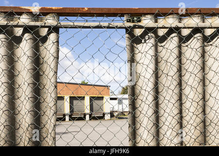 View through a lattice fence to a warehouse Stock Photo