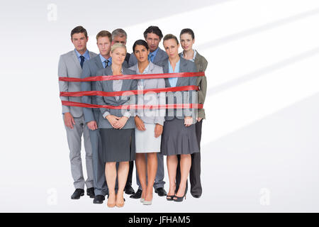 Composite image of upset business team fastened with adhesive tape Stock Photo