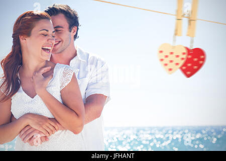 Composite image of happy couple hugging and laughing together Stock Photo