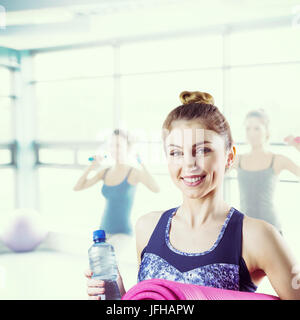 Composite image of fit brunette holding yoga mat Stock Photo