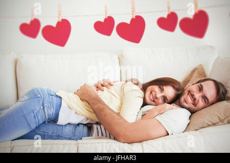 Composite image of cute couple relaxing on couch Stock Photo
