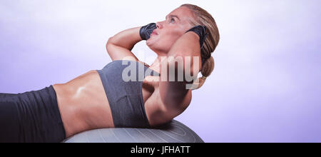 Composite image of muscular woman doing sit ups Stock Photo
