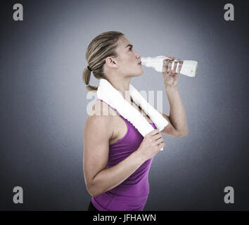 Composite image of muscular woman drinking water Stock Photo