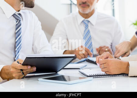 Mid section of businessmen and businesswomen discussing Stock Photo