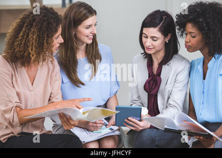 Female business colleagues interacting with each other Stock Photo