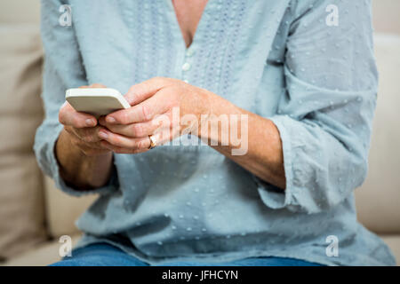 Midsection of senior woman using mobile phone Stock Photo