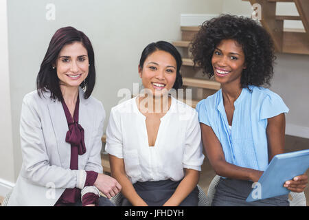 Female business colleagues discussing on digital tablet Stock Photo