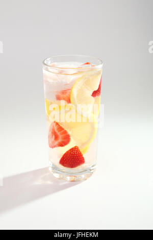 Cold cocktail with lemon and strawberries on a white background. Stock Photo