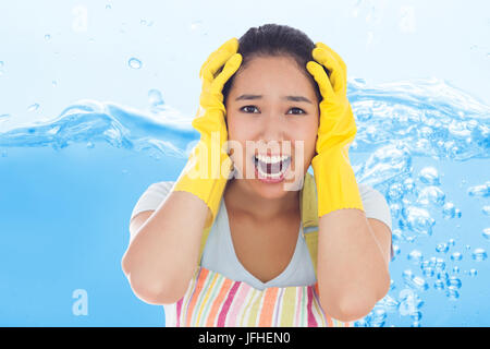Composite image of distressed woman wearing apron and rubber gloves Stock Photo