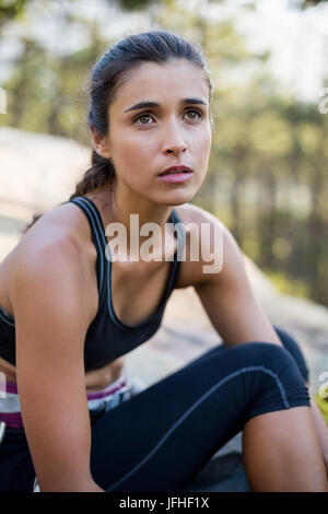 Portrait of woman looking up with climbing equipment Stock Photo