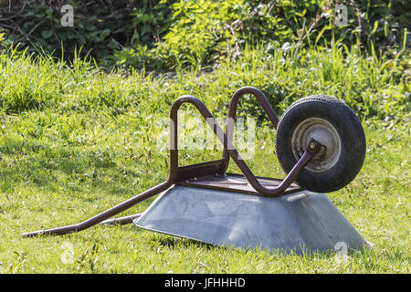 Wheelbarrow lying on a meadow Stock Photo