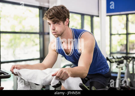 Man working out on exercise bike at spinning class Stock Photo