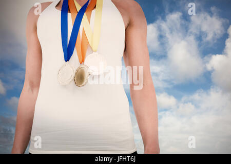 Composite image of female athlete wearing medals Stock Photo