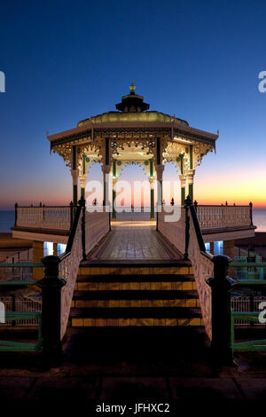 Brighton victorian bandstand at sunset, steps in foreground leading up to the bandstand, the bandstand is white and green and is made of ornate metal  Stock Photo