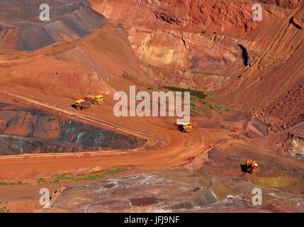 Mount Tom Price iron ore mine in operation with mining trucks. Stock Photo