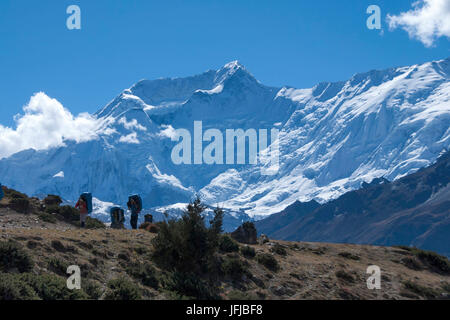 Porters on Annapurna Circuit, Annapurna II on background, Himalaya, Nepal Stock Photo