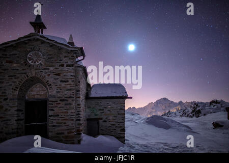 The church at the Alpe Prabello, Prabello Alp in a full moon night, Valmalenco, Valtellina, Italy Stock Photo