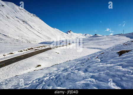 The road runs through the snow covered valley Albula Pass Bergün Canton of Graubünden Engadine Switzerland Europe Stock Photo