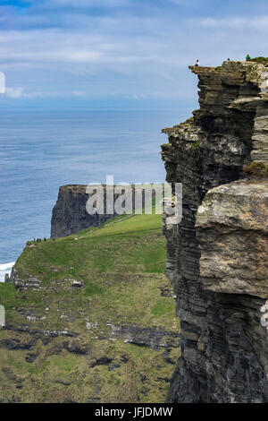 Person on the edge of a cliff at Cliffs of Moher, Liscannor, Munster, Co, Clare, Ireland, Europe, Stock Photo